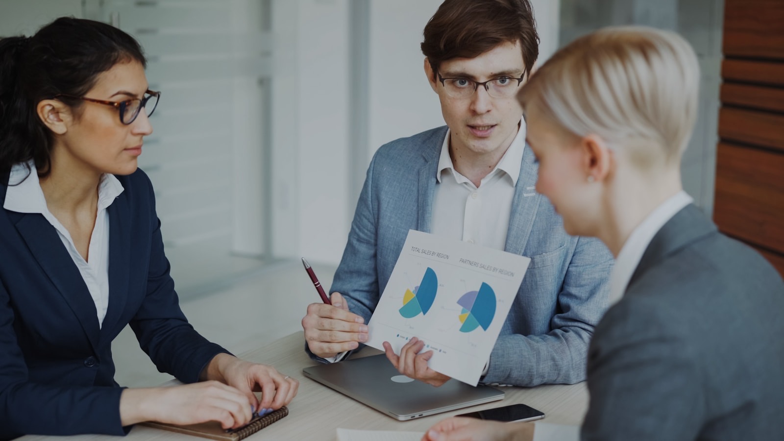 Professionals reviewing compliance reporting documents together